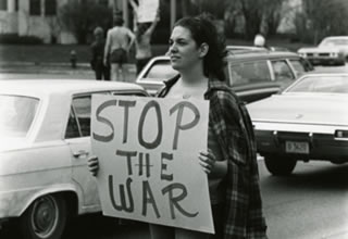 An unidentified Hamline student holding a STOP THE WAR sign in the 1970s