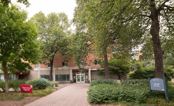 The front door of Sorin Hall at Hamline University, with a sign that says &quot;Welcome Pipers!&quot;