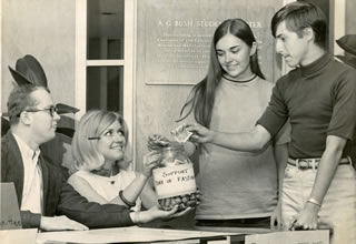 Hamline students from 1968 donating into a jar that says "SUPPORT DAY OF FASTING"