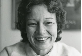 A black and white photo of an unidentified women holding a mug