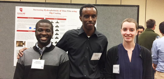 3 students smiling at the conference