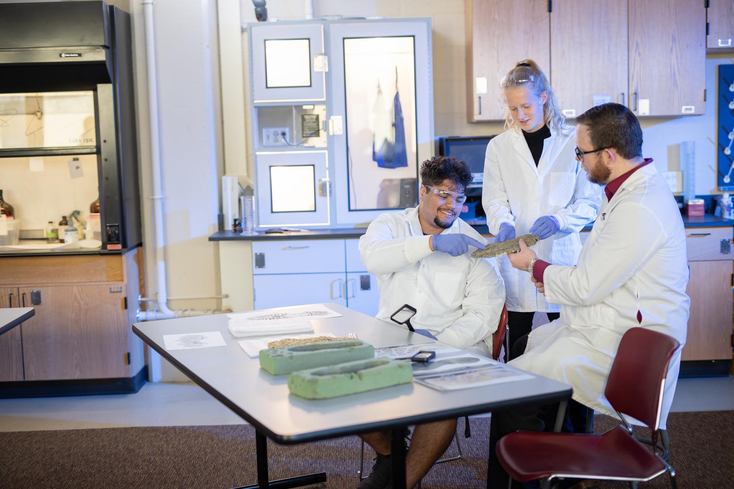 Forensics students and professor looking at crime scene evidence