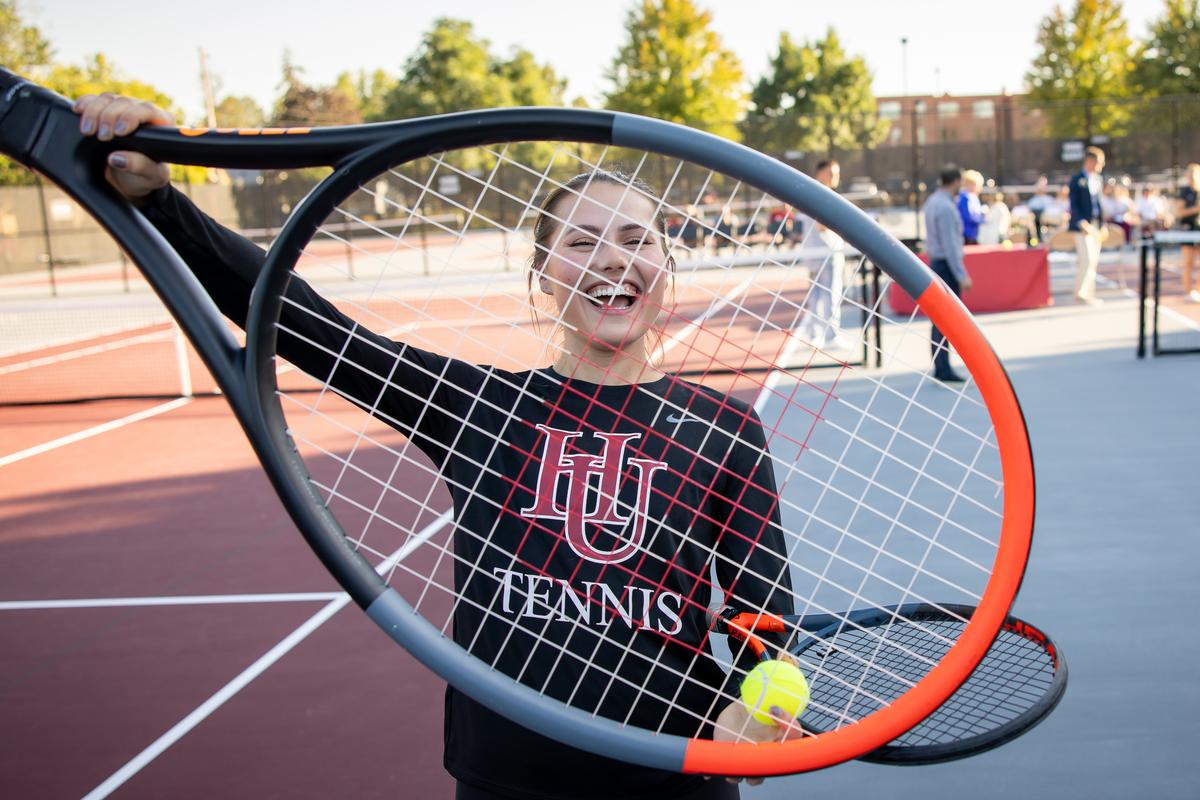 Hamline student holding up tennis racket