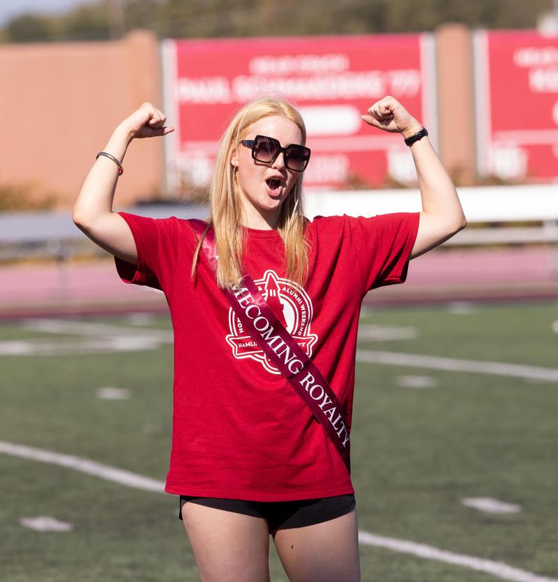 A Hamline student flexing on a football field