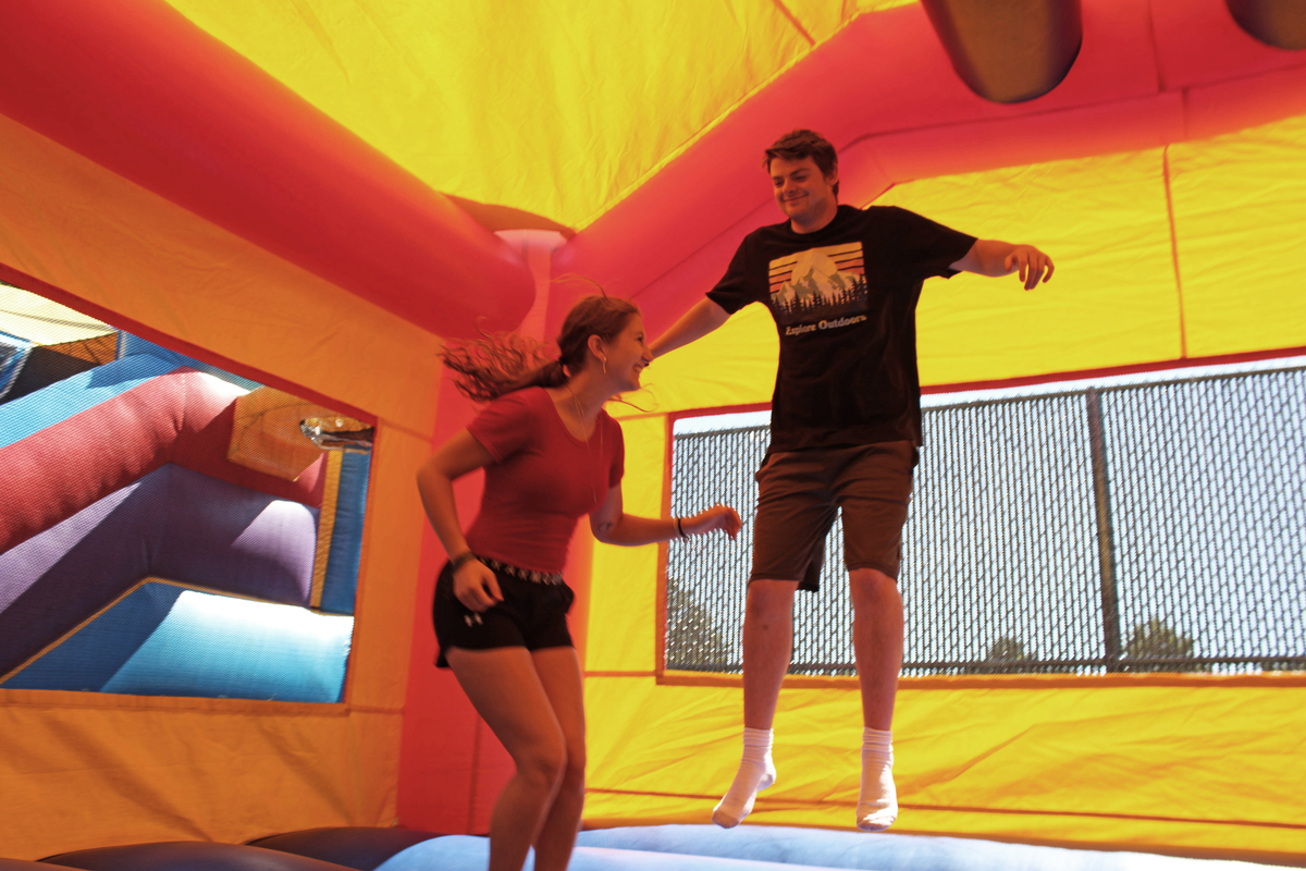 Students jumping in bounce house, Fall Welcome Week