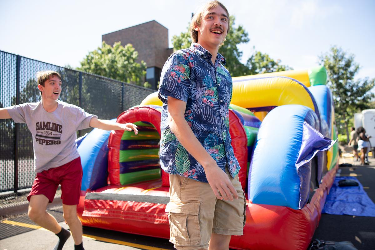 Two students with bounce house, during Fall Welcome Week