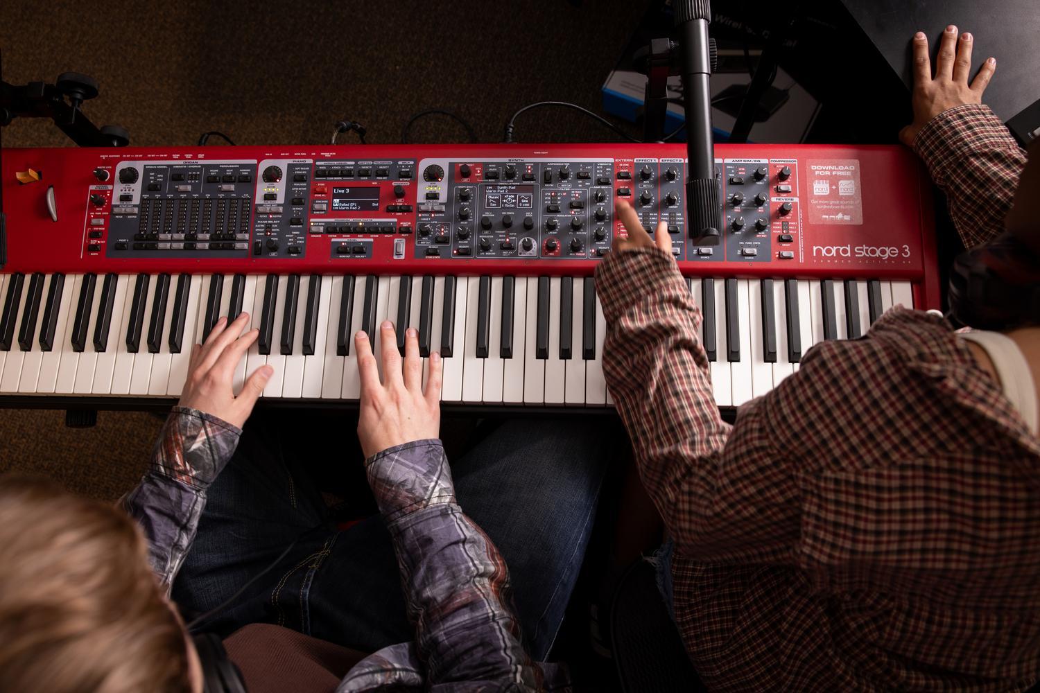 Hands on keyboards in the music production studio