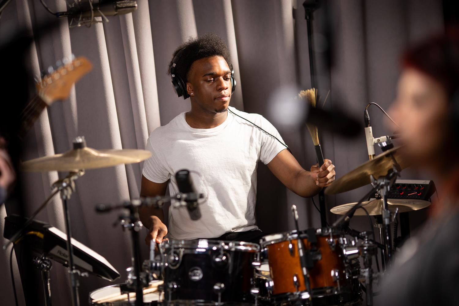 Joe Mason playing drums in the music production studio