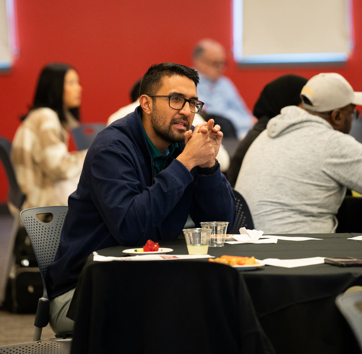 Man seated at a table at first-generation pinning ceremony
