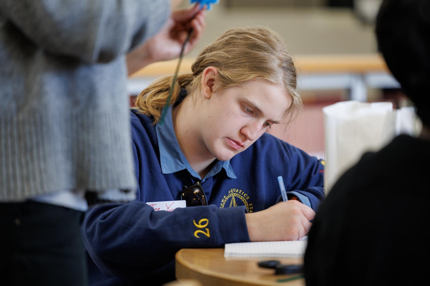 TRiO student writing in notebook