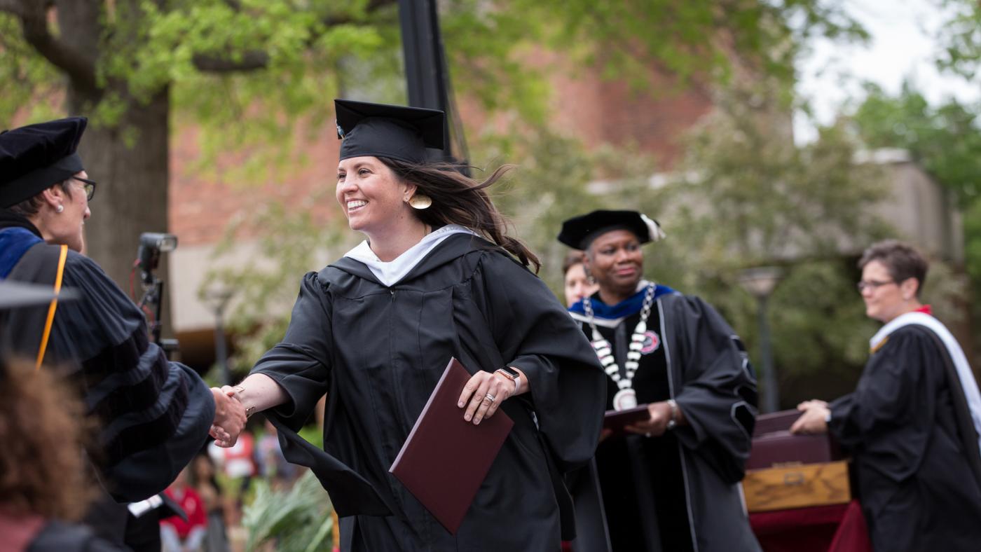 A graduate earns their degree at Commencement.