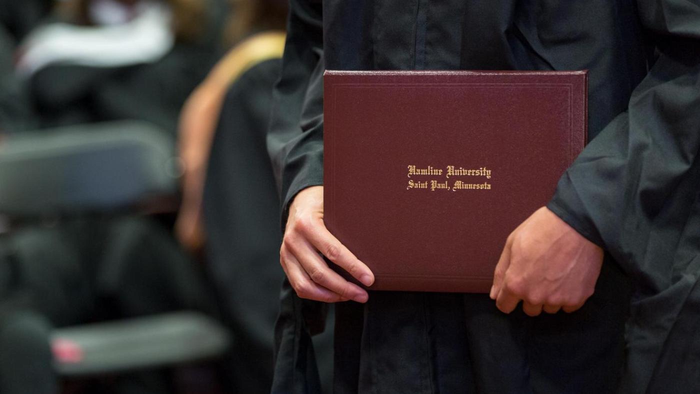 A graduate holds a diploma