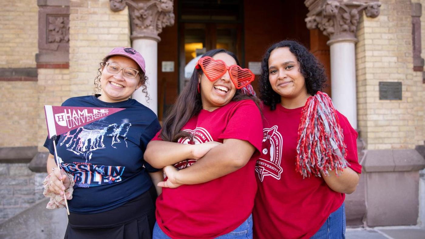 Three Hamline students with pennants at Homecoming