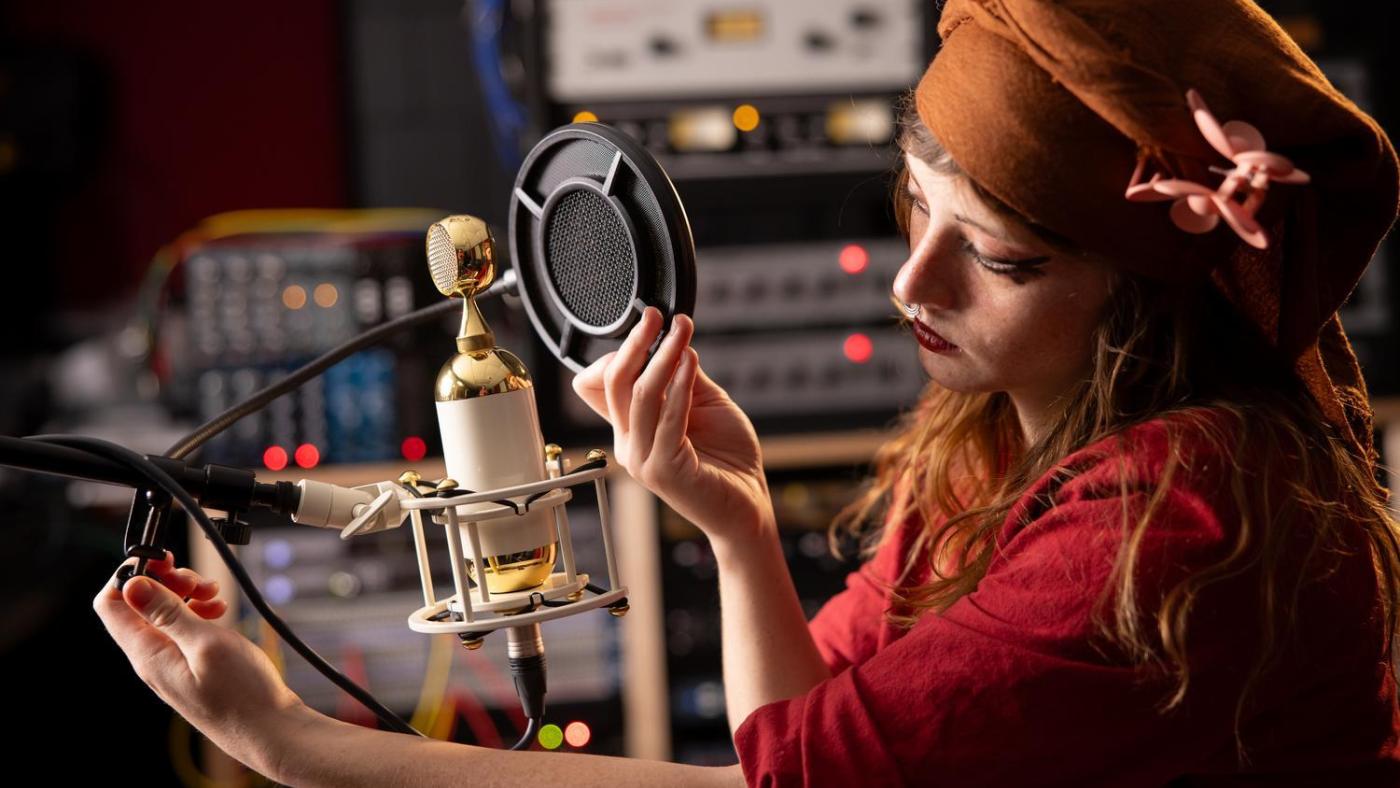 Student using microphone in the music production studio