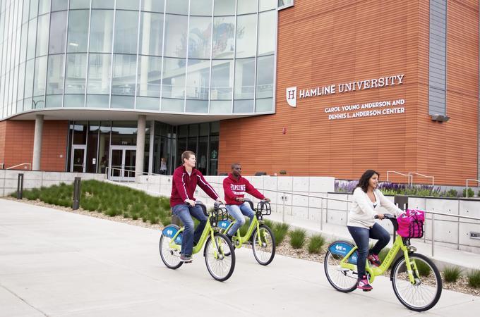 Students biking in front of Hamline Anderson Center
