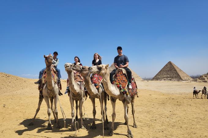 Students riding on Camels in front of the pyramids in Egypt