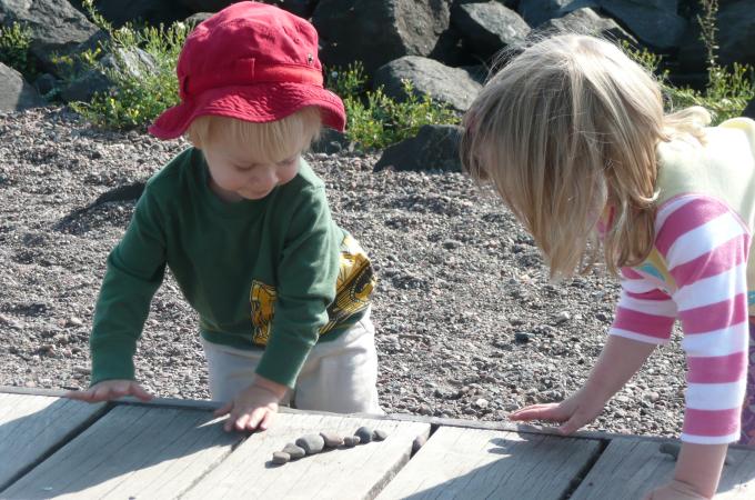 Two young children looking at rocks