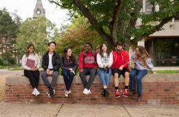 Students sitting on wall on campus