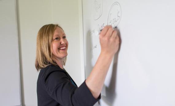 Hamline professor Tina writing in a white board