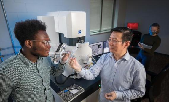 Two Hamline students and a professor working in a science lab on campus