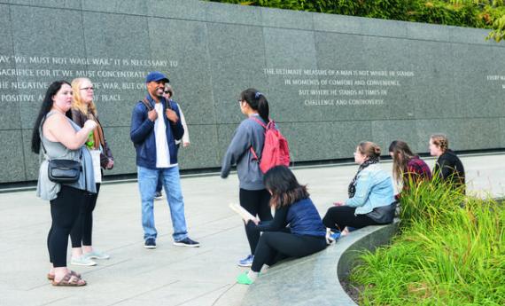 A group of Hamline students standing in front of an outdoor social justice display