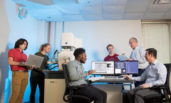 A group of Hamline students and faculty working together in a campus science lab