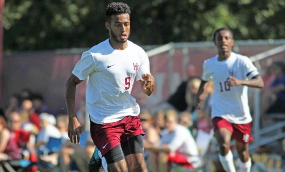 Two Hamline soccer players running on the field during a game