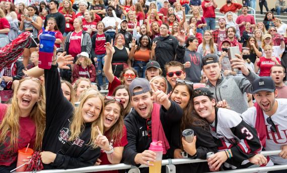 Hamline students and alumni cheering at homecoming game, athletics