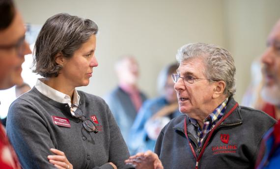 Professor Hostetter listening to man wearing a Hamline sweater during Alumni Weekend