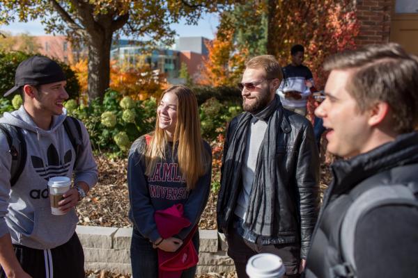 Hamline students standing outside in fall, holding coffee