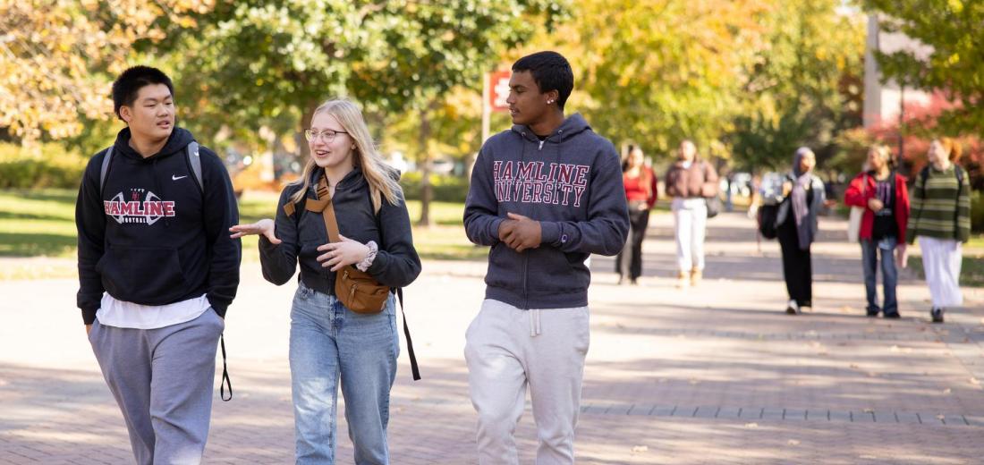Three students walking on Hamline campus