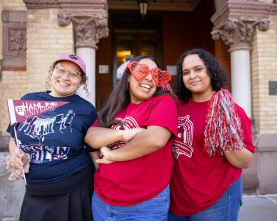 Three Hamline students with pennants at Homecoming