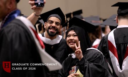 Students taking selfies at the 2026 Graduate Commencement Ceremony