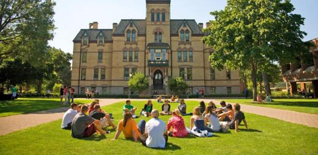 a group of students sitting together outside of Old Main
