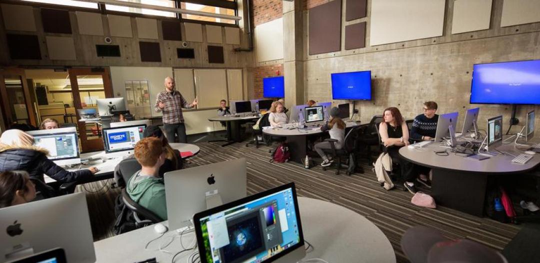 Photo of professor and students in the digital media arts lab