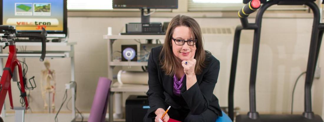 Exercise Science professor Lisa Ferguson Stegall sitting amongst exercise equipment