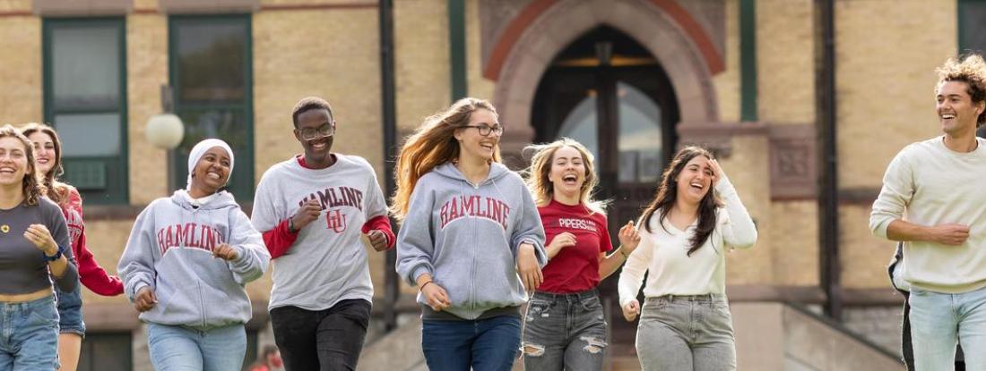 A group of Hamline Students interacting with each other on campus at Hamline Old Main