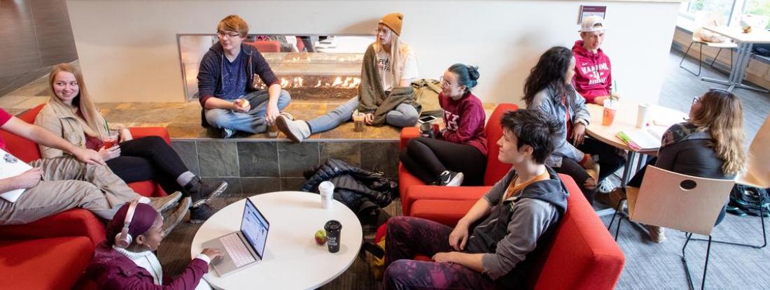 A group of Hamline students sitting and talking on couches and tables
