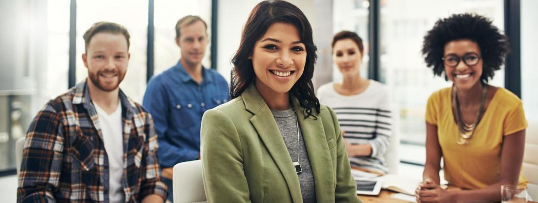 Five people are in the meeting and smiling for the picture
