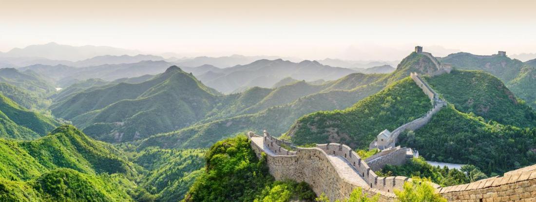 The Great Wall of China surrounded by rolling green hills