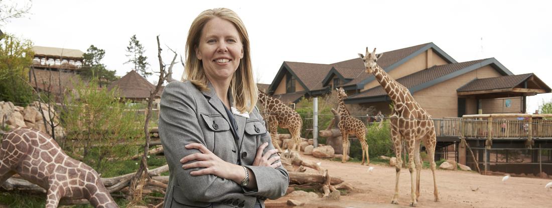 Woman standing in front of giraffes at a zoo