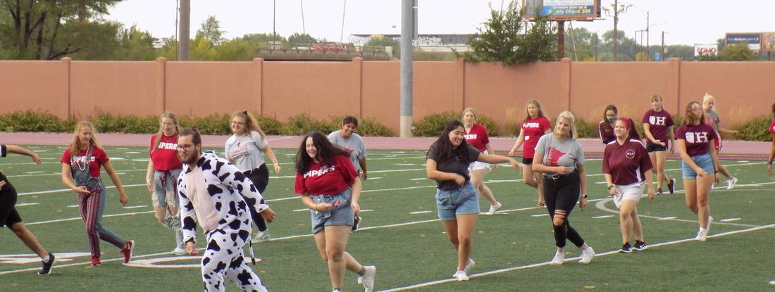 Hamline NSMs and Students performing the annual piper boogie on Klas Field