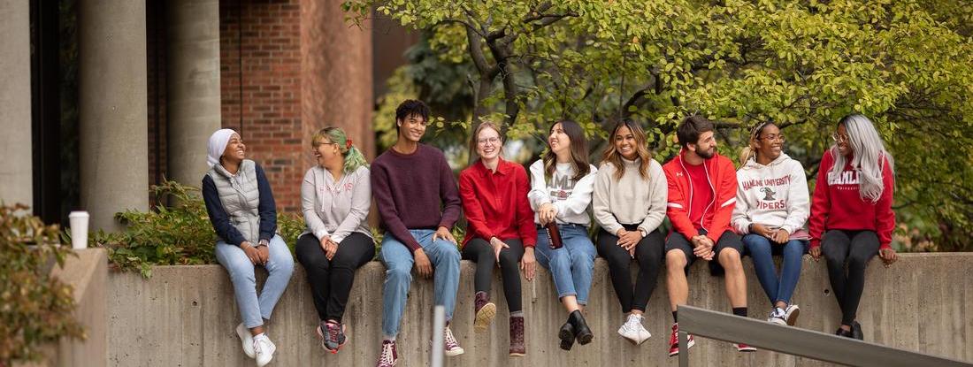 A group of Hamline students sitting on the wall
