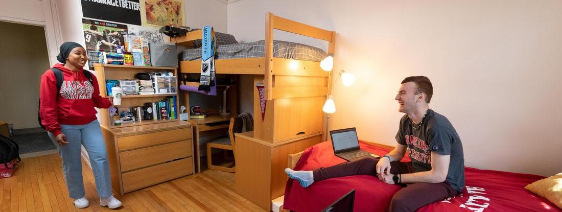 Two Hamline students talking in a Hamline dorm room