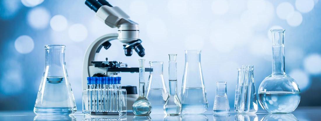 a line of blue chemistry beakers and a microscope