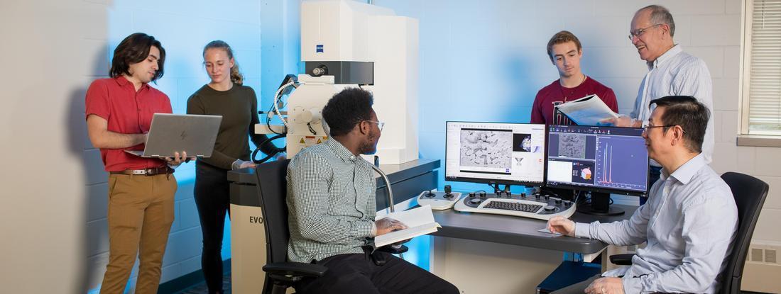 Photo of students and professors collaborating on the Scanning Electron Microscope