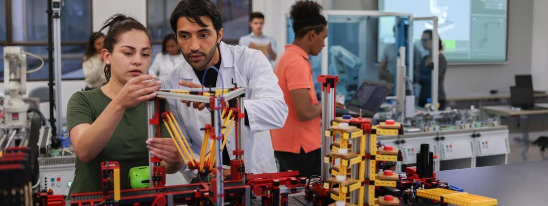 A teacher helps a student on a lab project