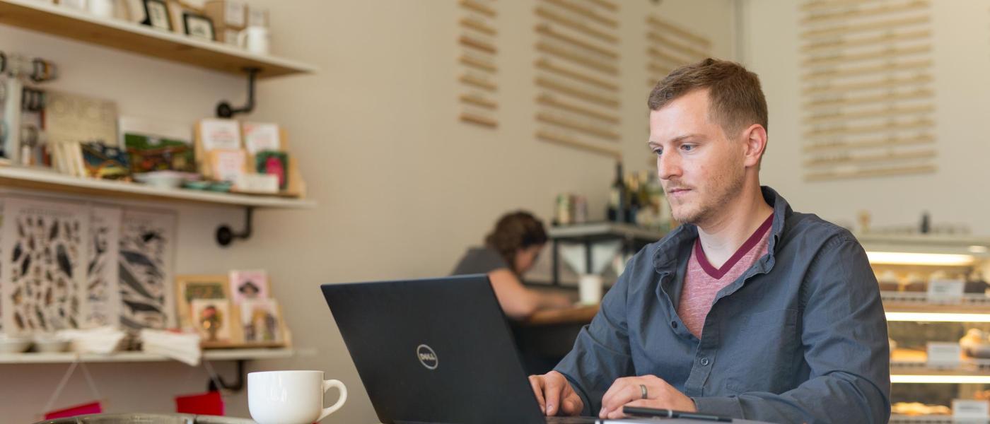 Online degree completion, student working in coffeeshop