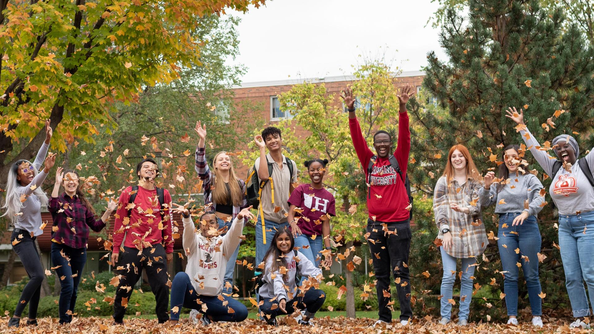 Hamline happy students at Hamline during the fall blowing the leafs