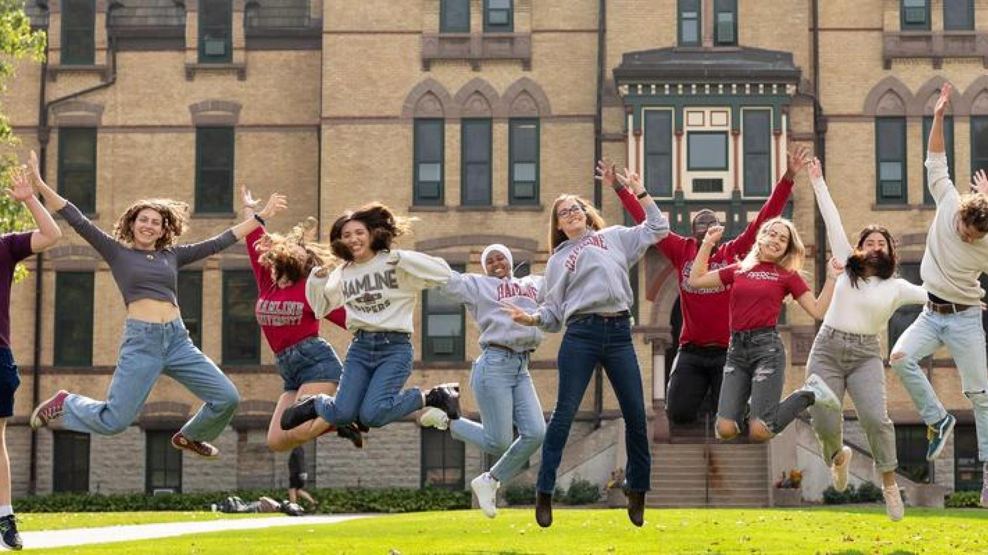 Students jumping in front of Hamline Old Main